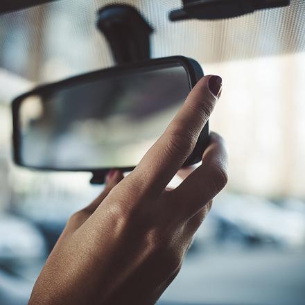 Hand adjusting a rearview mirror