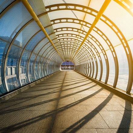 Empty tunnel with footpath lit by sunset