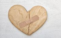 Broken wooden heart cutting board with bandaid