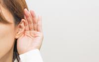 Half woman's face with her hand up to her ear